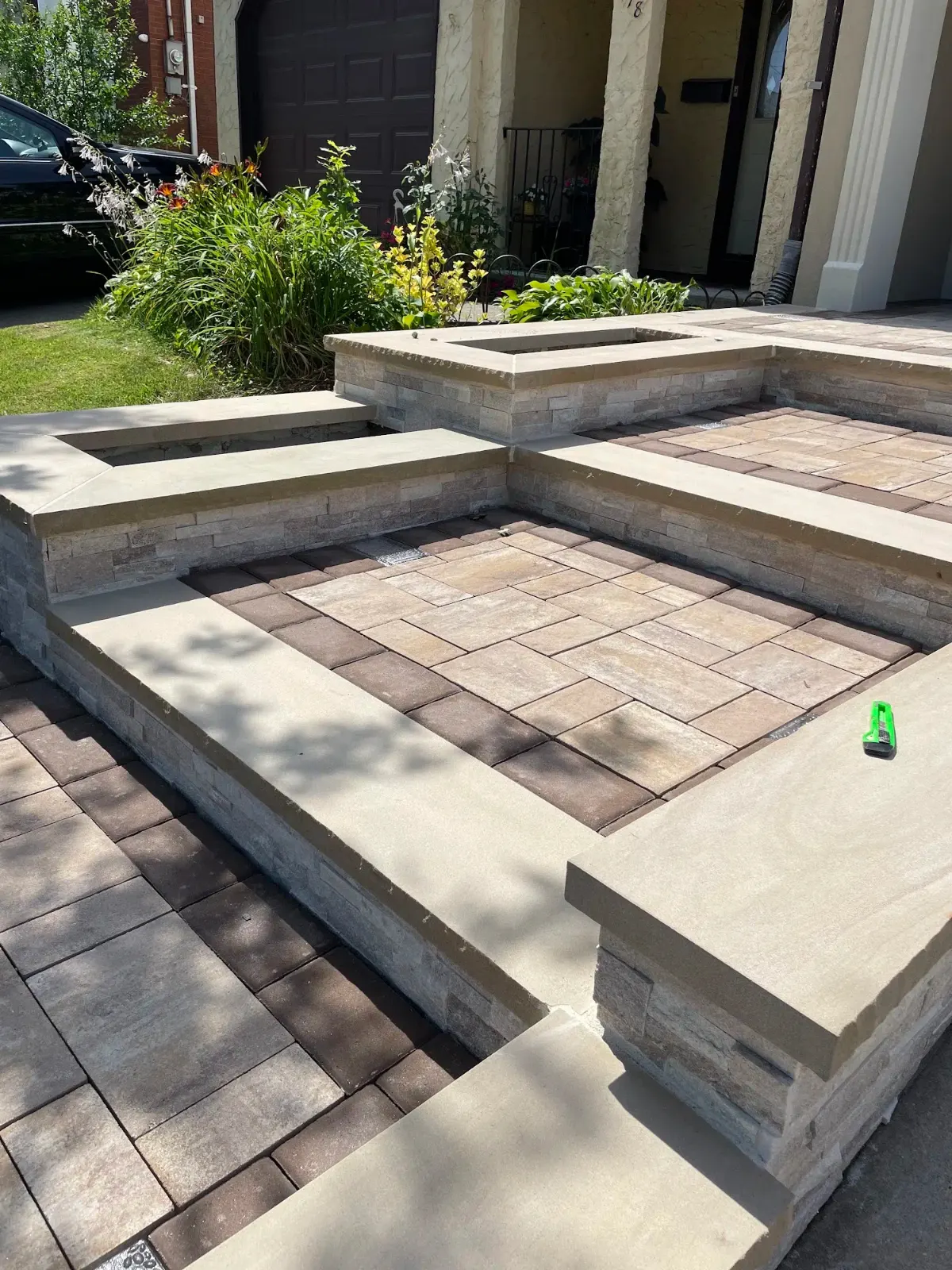 Tiered stone seating walls and paver patio in tan and brown tones — APPLE MASONRY INC in Staten Island