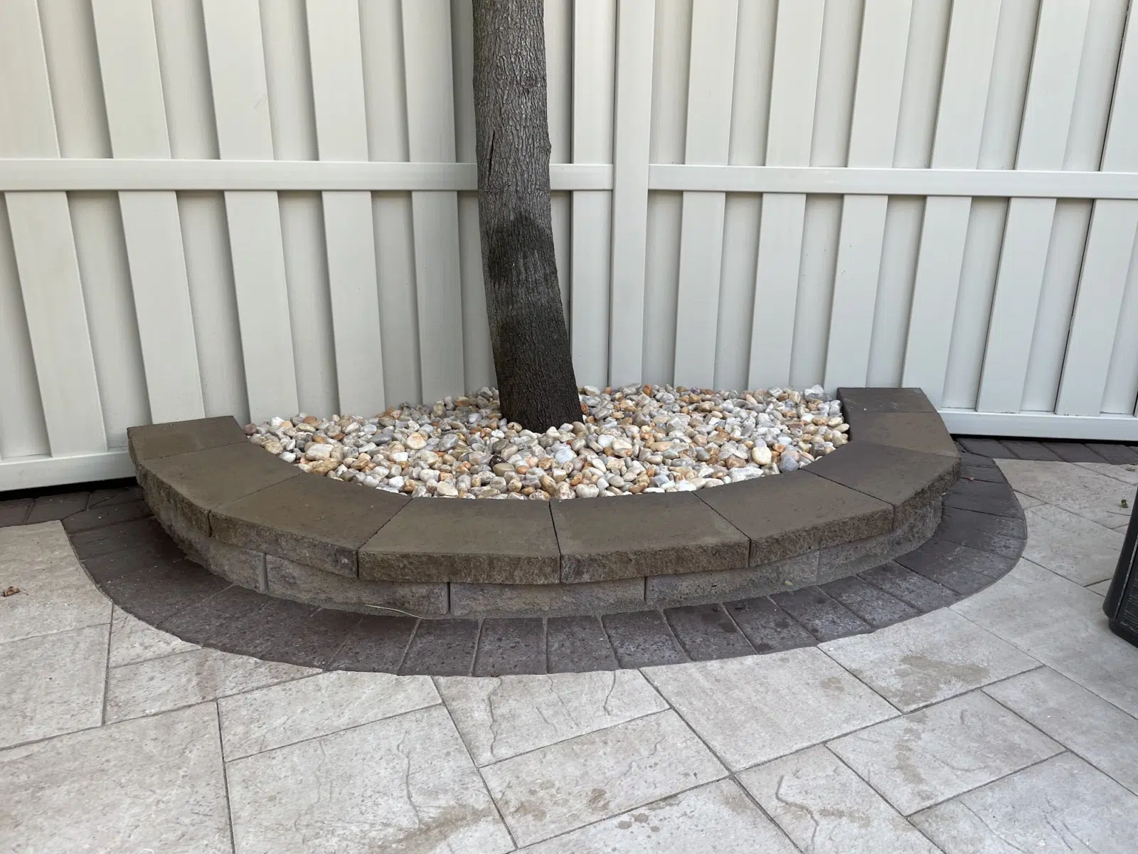Curved stone retaining border with river rock around tree trunk — APPLE MASONRY INC in Brooklyn