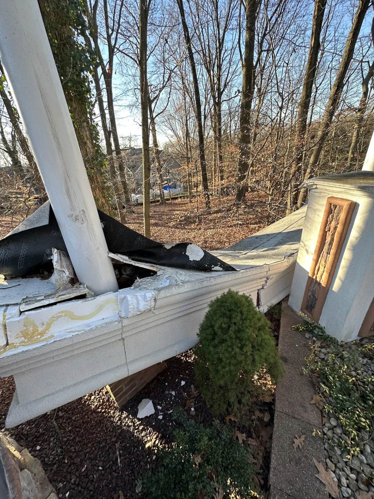 Damaged masonry wall and roof edge under repair beside trees — APPLE MASONRY INC in Brooklyn